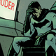Batman sitting in the Batcave.
